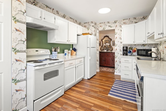 kitchen with white cabinetry, sink, light hardwood / wood-style flooring, and white appliances