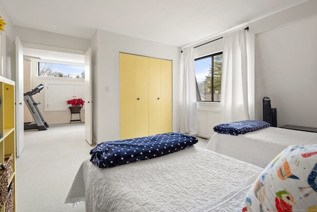 bedroom with light colored carpet, a closet, and multiple windows