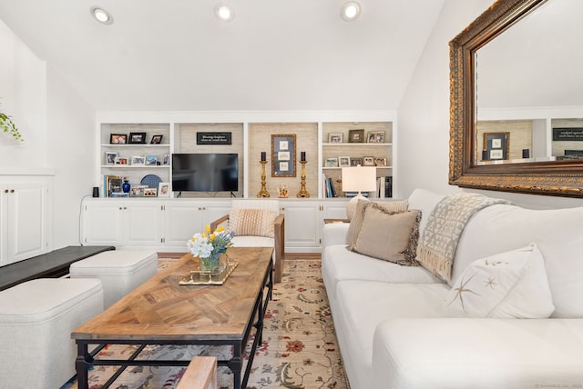 living room with built in shelves and vaulted ceiling