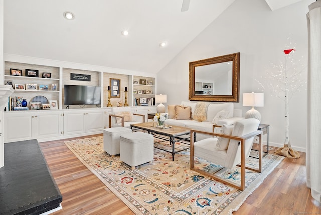 living room with light wood-type flooring, high vaulted ceiling, and built in shelves