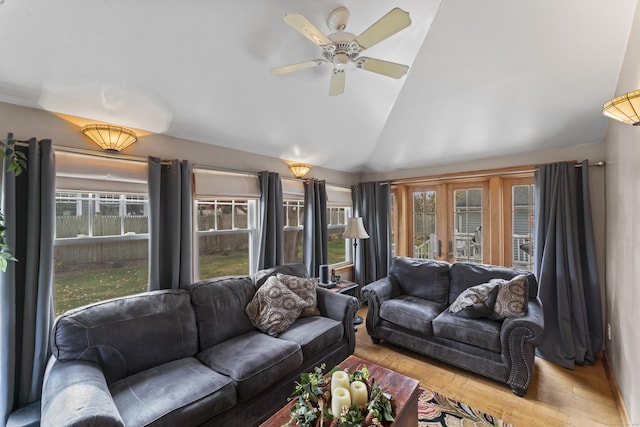 living room with light wood-type flooring, ceiling fan, vaulted ceiling, and a healthy amount of sunlight