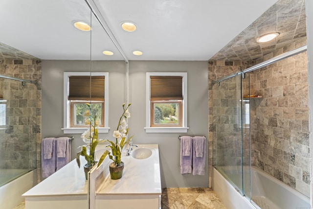 bathroom featuring vanity, combined bath / shower with glass door, and plenty of natural light