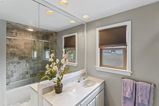 bathroom featuring combined bath / shower with glass door and vanity