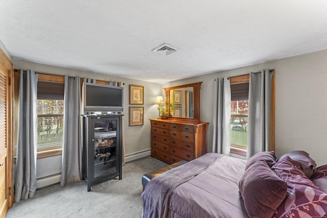 bedroom featuring light colored carpet and a baseboard heating unit