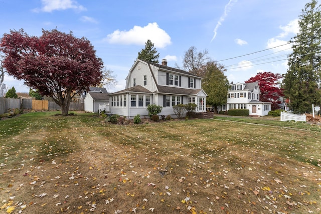 view of front of home featuring a front yard and a storage shed