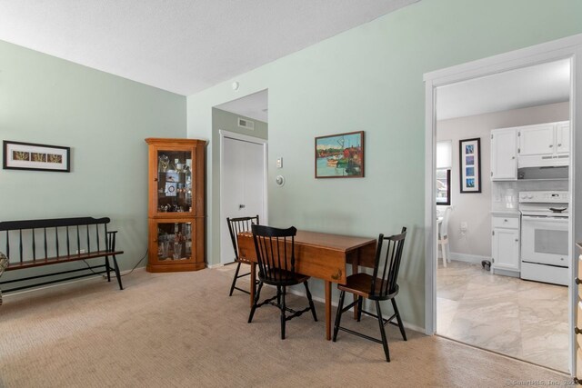 dining area featuring light carpet