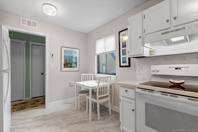 kitchen with tasteful backsplash, white appliances, and white cabinets