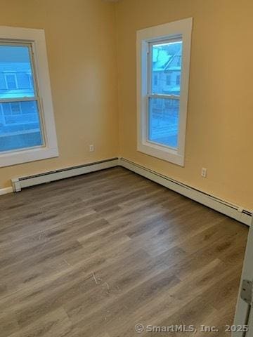 unfurnished room featuring light hardwood / wood-style flooring and a baseboard radiator