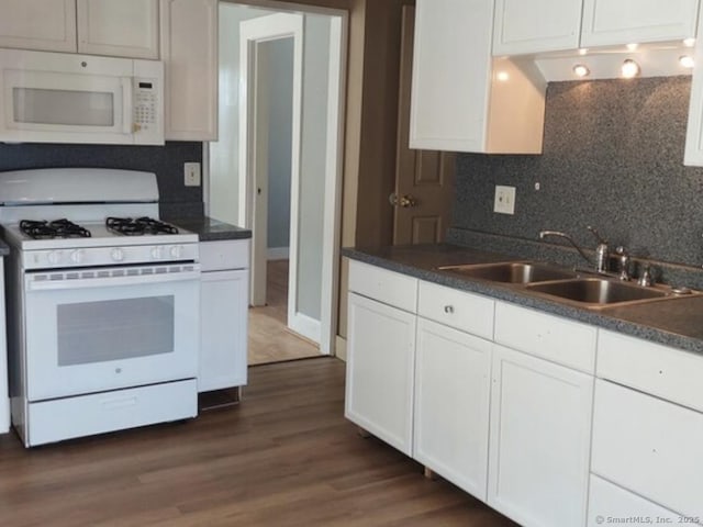 kitchen with tasteful backsplash, white cabinetry, sink, and white appliances