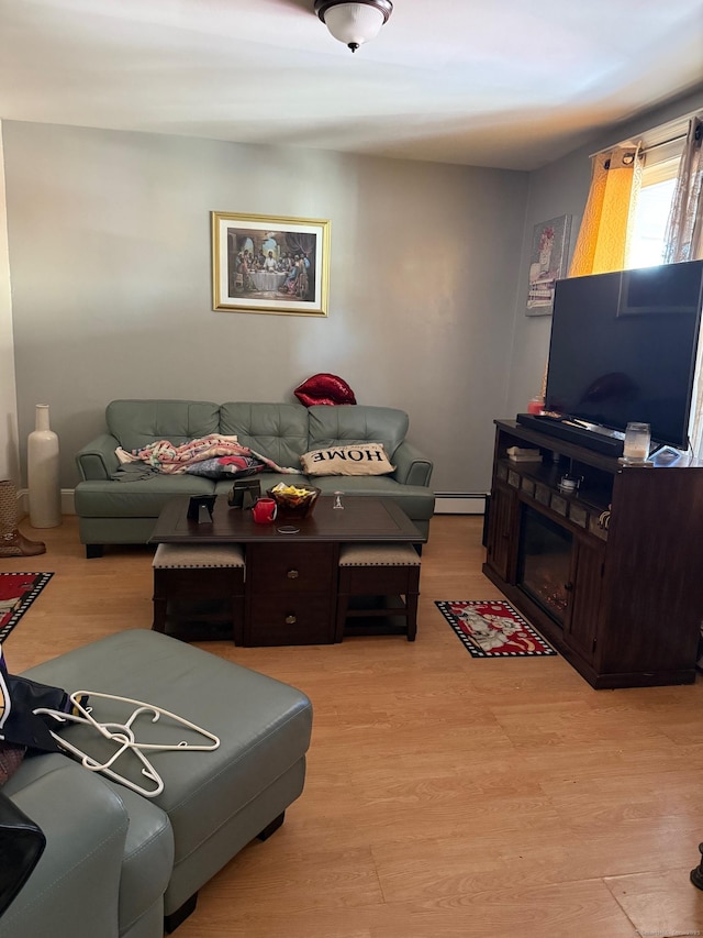 living room featuring a baseboard heating unit and light hardwood / wood-style floors