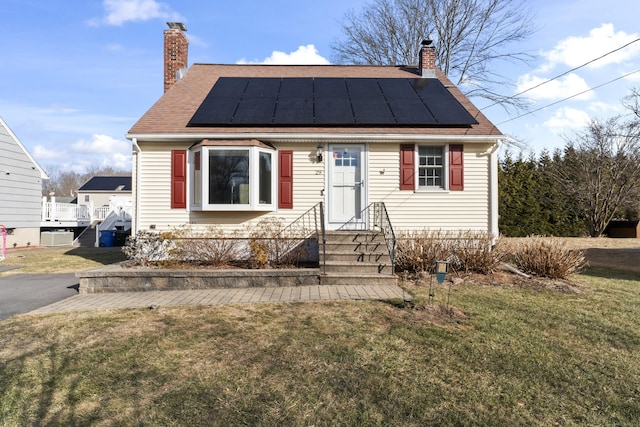 bungalow-style home featuring a front lawn and solar panels