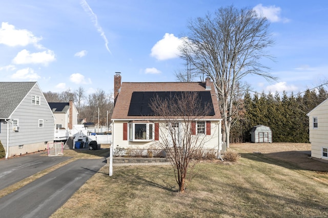 view of front of house with a storage unit and a front yard