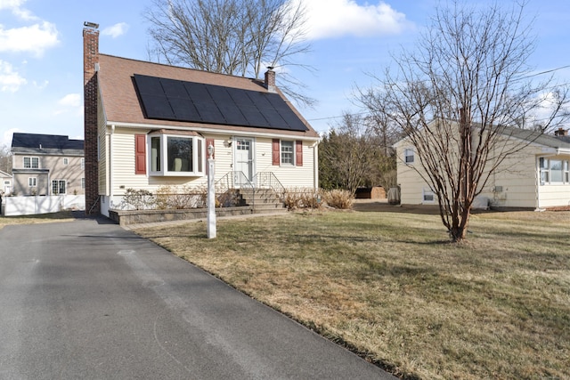 view of front of home with a front lawn and solar panels