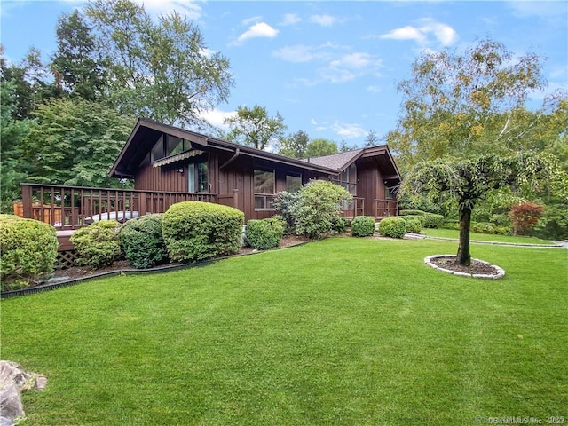 view of front facade with a front yard and a deck