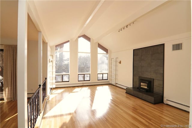 unfurnished living room featuring light wood-type flooring, baseboard heating, and lofted ceiling