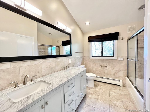 full bathroom featuring toilet, combined bath / shower with glass door, a baseboard heating unit, lofted ceiling, and tile walls