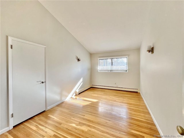 spare room with a baseboard heating unit and light hardwood / wood-style flooring