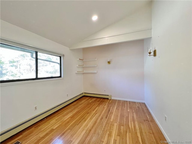 spare room with light wood-type flooring, baseboard heating, and lofted ceiling