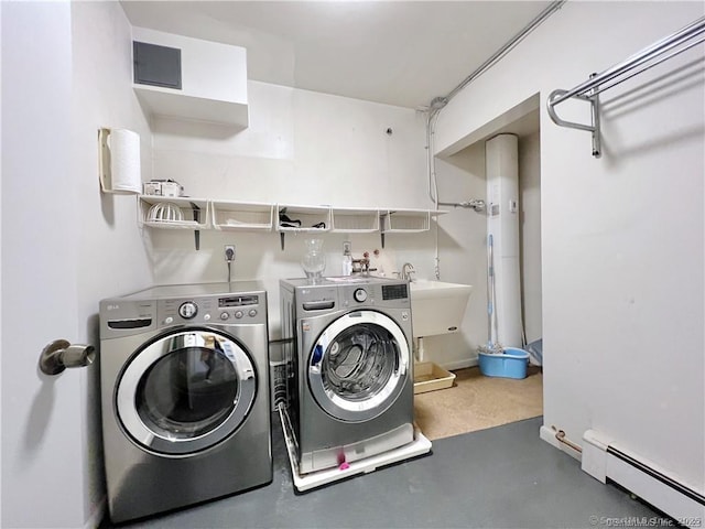 washroom with baseboard heating, sink, and washing machine and dryer