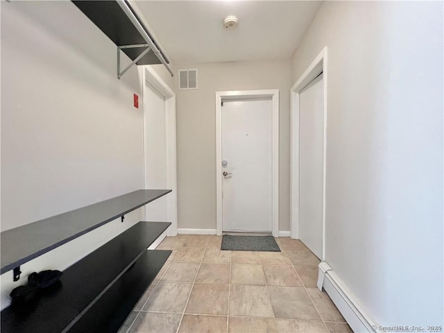 doorway with baseboard heating and light tile patterned flooring