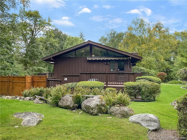 view of home's exterior featuring a deck and a yard