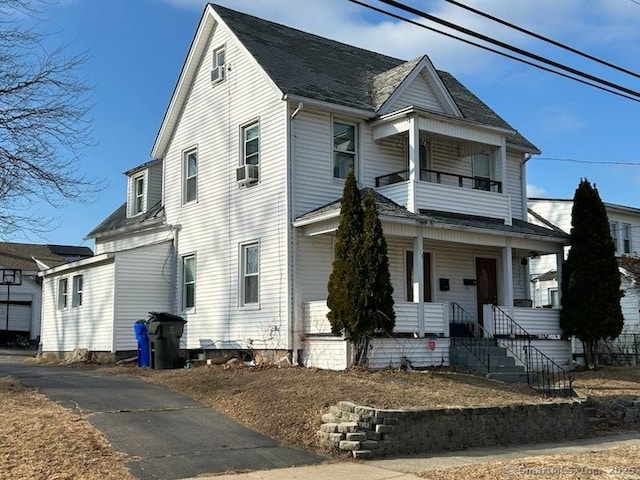 view of front of property with a balcony, a porch, and cooling unit