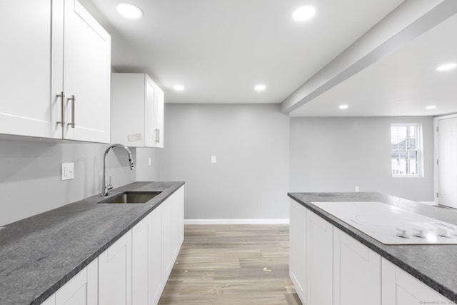 kitchen with white cabinets, light hardwood / wood-style floors, and sink