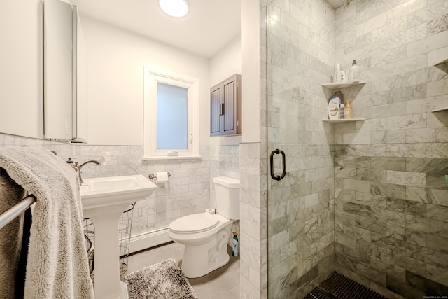 bathroom featuring a shower with shower door, tile walls, and toilet