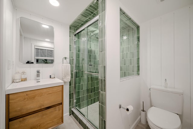 bathroom featuring toilet, vanity, and an enclosed shower