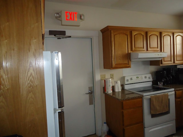 kitchen with white range with electric cooktop, stainless steel fridge, and dark stone counters