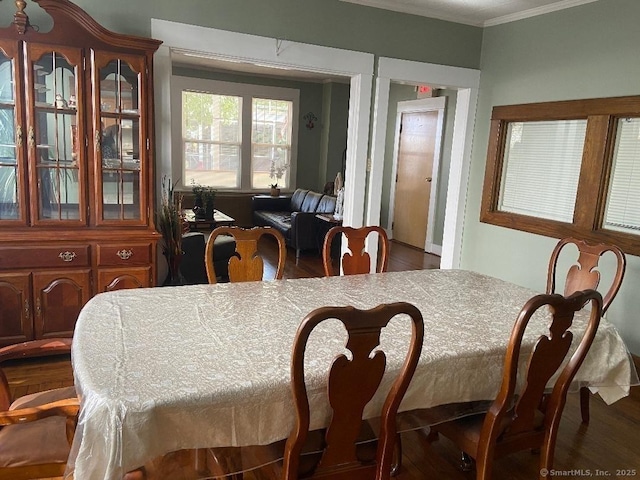 dining space with dark hardwood / wood-style floors and ornamental molding