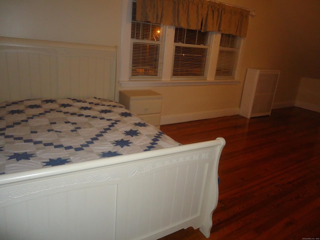 bedroom with dark hardwood / wood-style floors