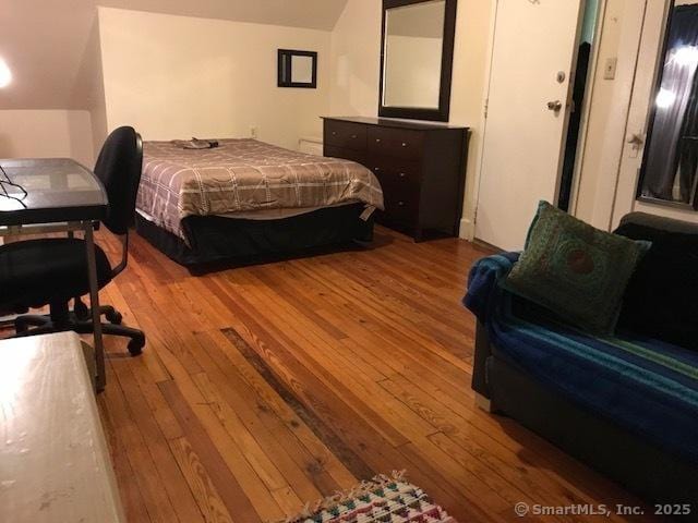 bedroom with lofted ceiling and light hardwood / wood-style flooring