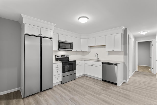 kitchen with white cabinetry, stainless steel appliances, decorative backsplash, sink, and light hardwood / wood-style flooring