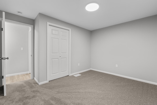 unfurnished bedroom with a closet and carpet flooring