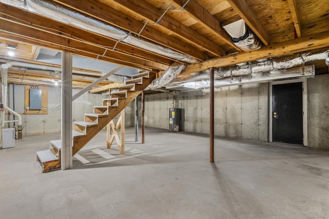 basement featuring water heater and electric panel