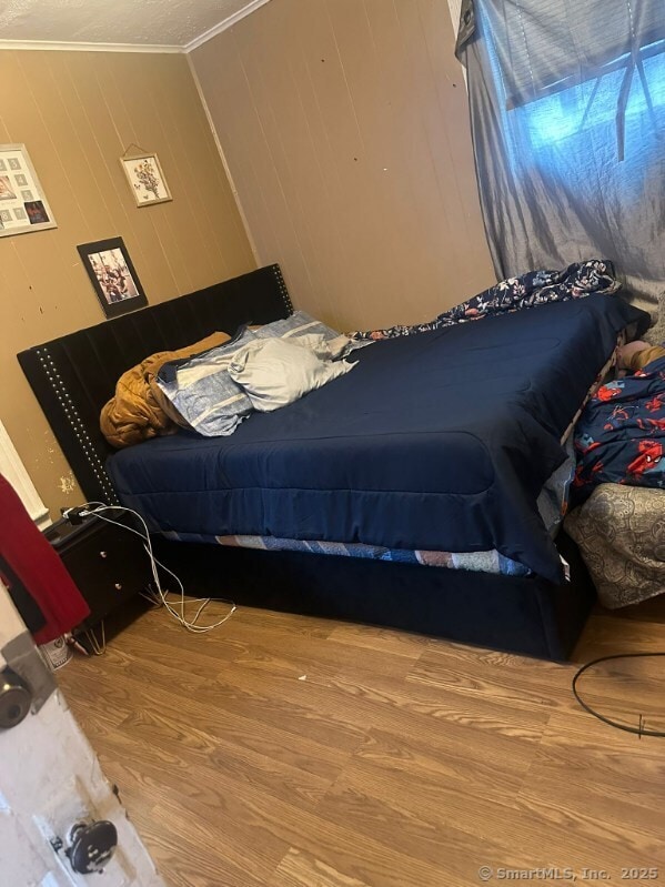 bedroom featuring hardwood / wood-style flooring and ornamental molding