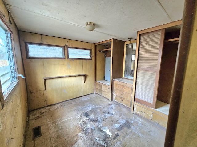 unfurnished bedroom with wooden walls