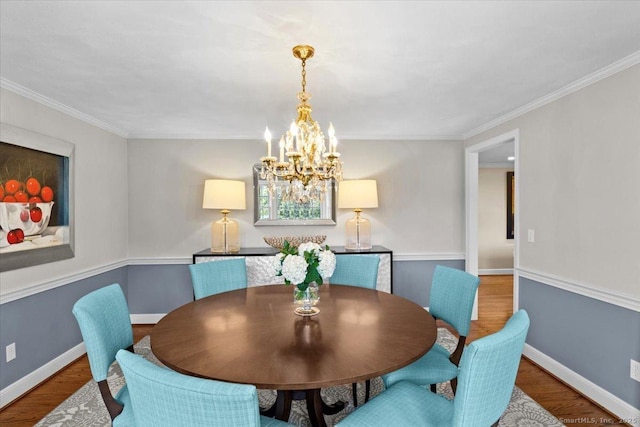 dining area featuring ornamental molding, hardwood / wood-style flooring, and a notable chandelier