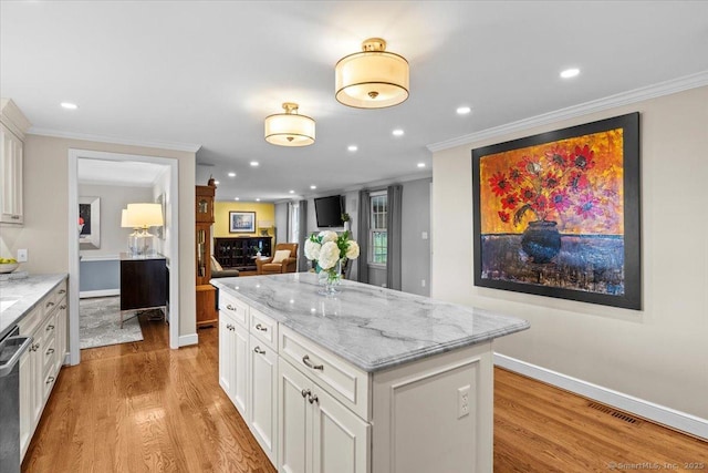 kitchen featuring white cabinetry, crown molding, and light stone counters