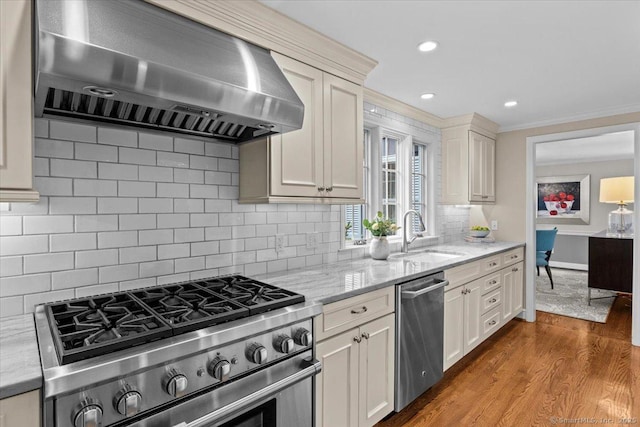 kitchen with exhaust hood, backsplash, sink, and stainless steel appliances