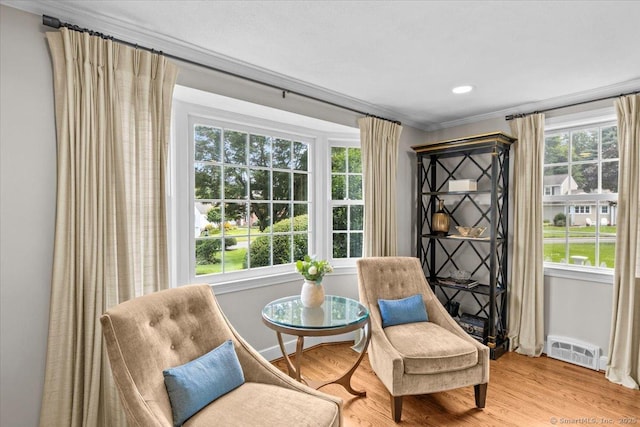 sitting room featuring a healthy amount of sunlight, light wood-type flooring, and crown molding