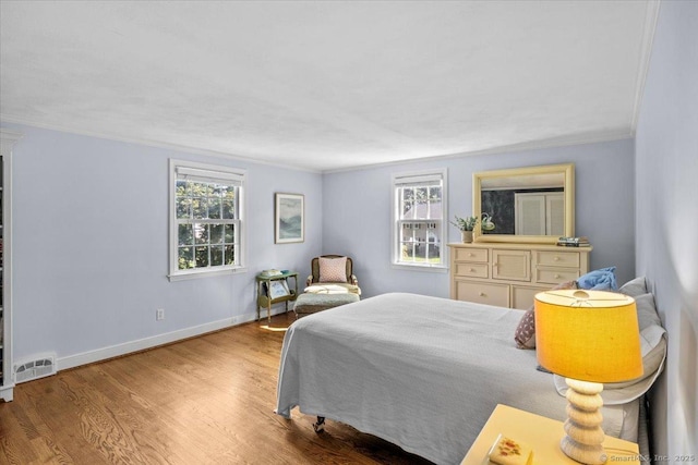 bedroom with wood-type flooring and ornamental molding