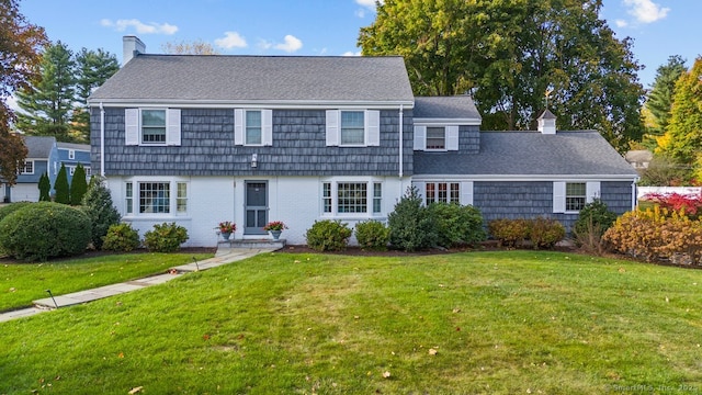 colonial-style house featuring a front lawn