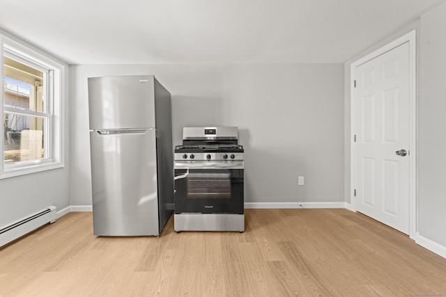 kitchen featuring a baseboard heating unit, appliances with stainless steel finishes, and light wood-type flooring