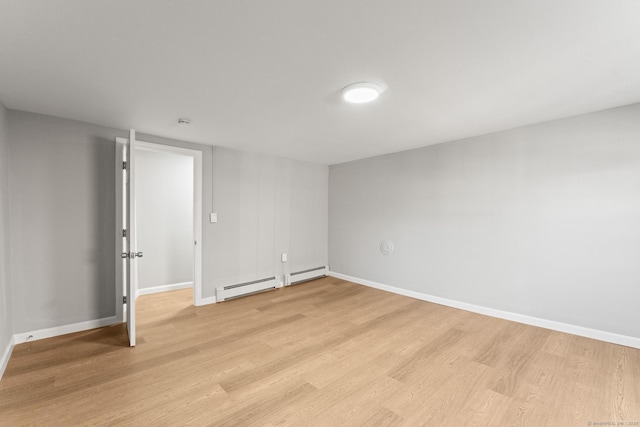 interior space featuring a baseboard heating unit and light hardwood / wood-style floors