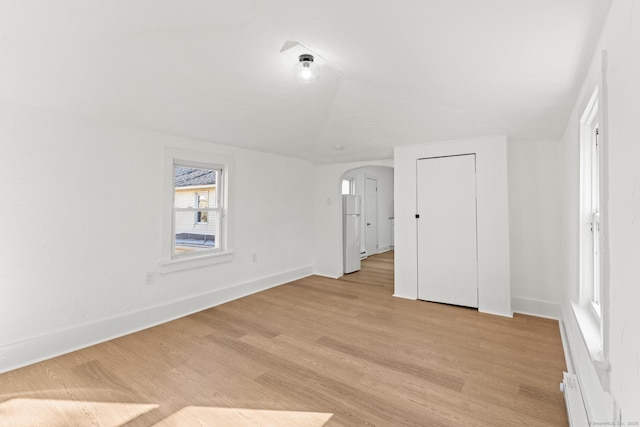 unfurnished bedroom with white fridge and light wood-type flooring