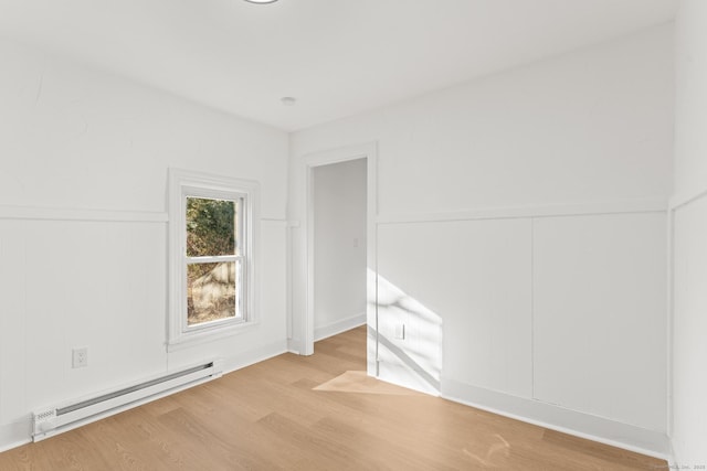 empty room with light wood-type flooring and a baseboard radiator