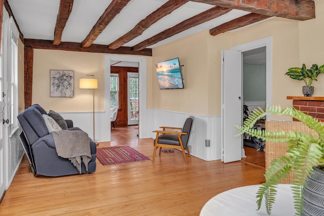 living room with beam ceiling and light hardwood / wood-style flooring