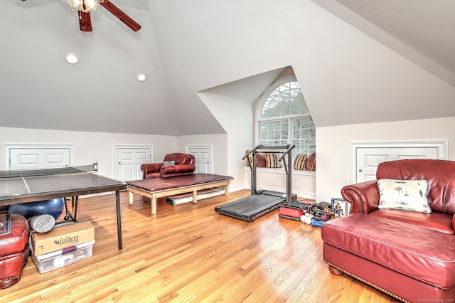 workout room with ceiling fan, wood-type flooring, and vaulted ceiling